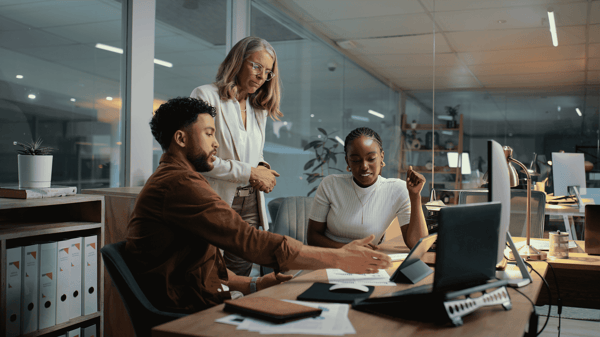 Image depicts colleagues discussing payroll management.