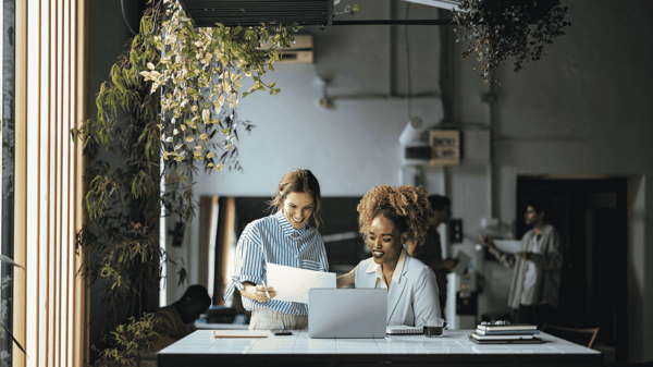 Image depicts two colleagues discussing Workday Reporting