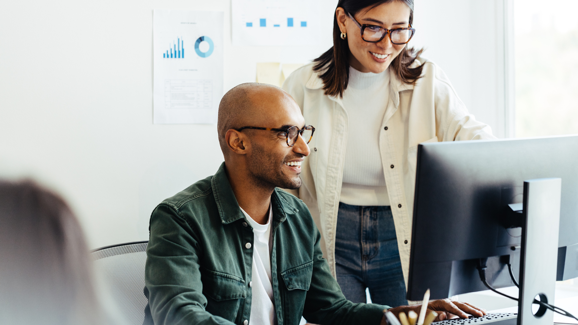 Image depicts two payroll professionals discussing Workday Payroll